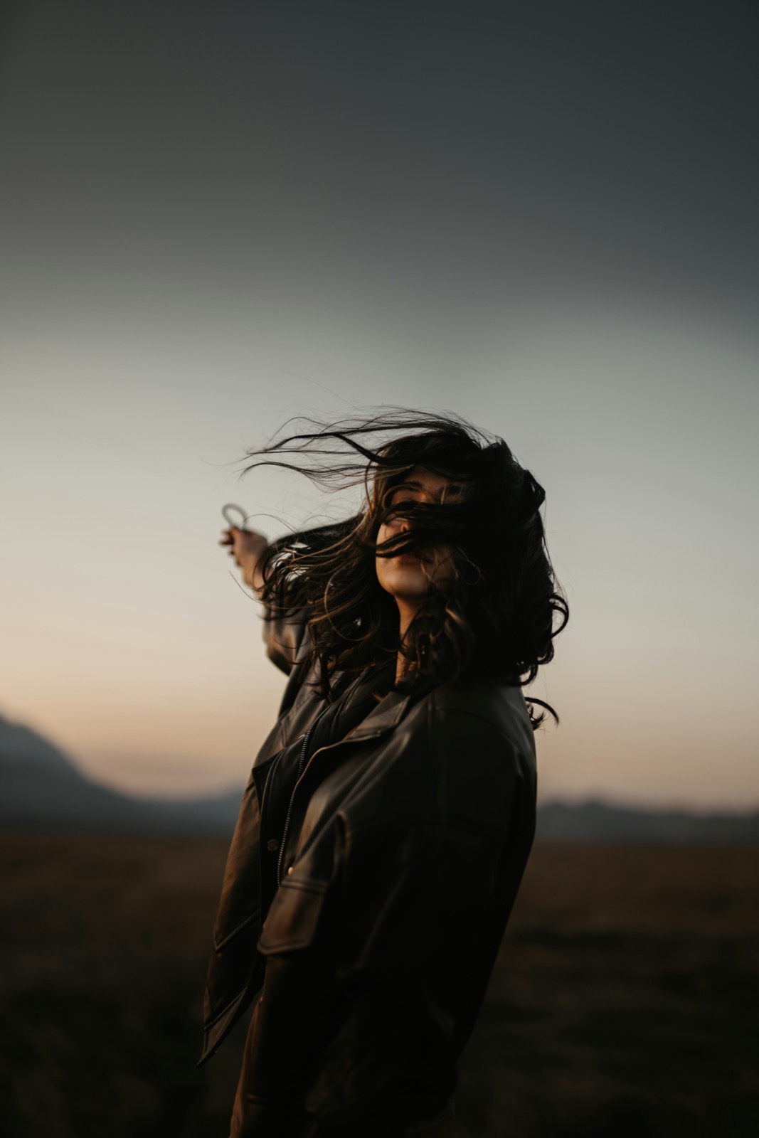 A person at dusk, wind in their hair